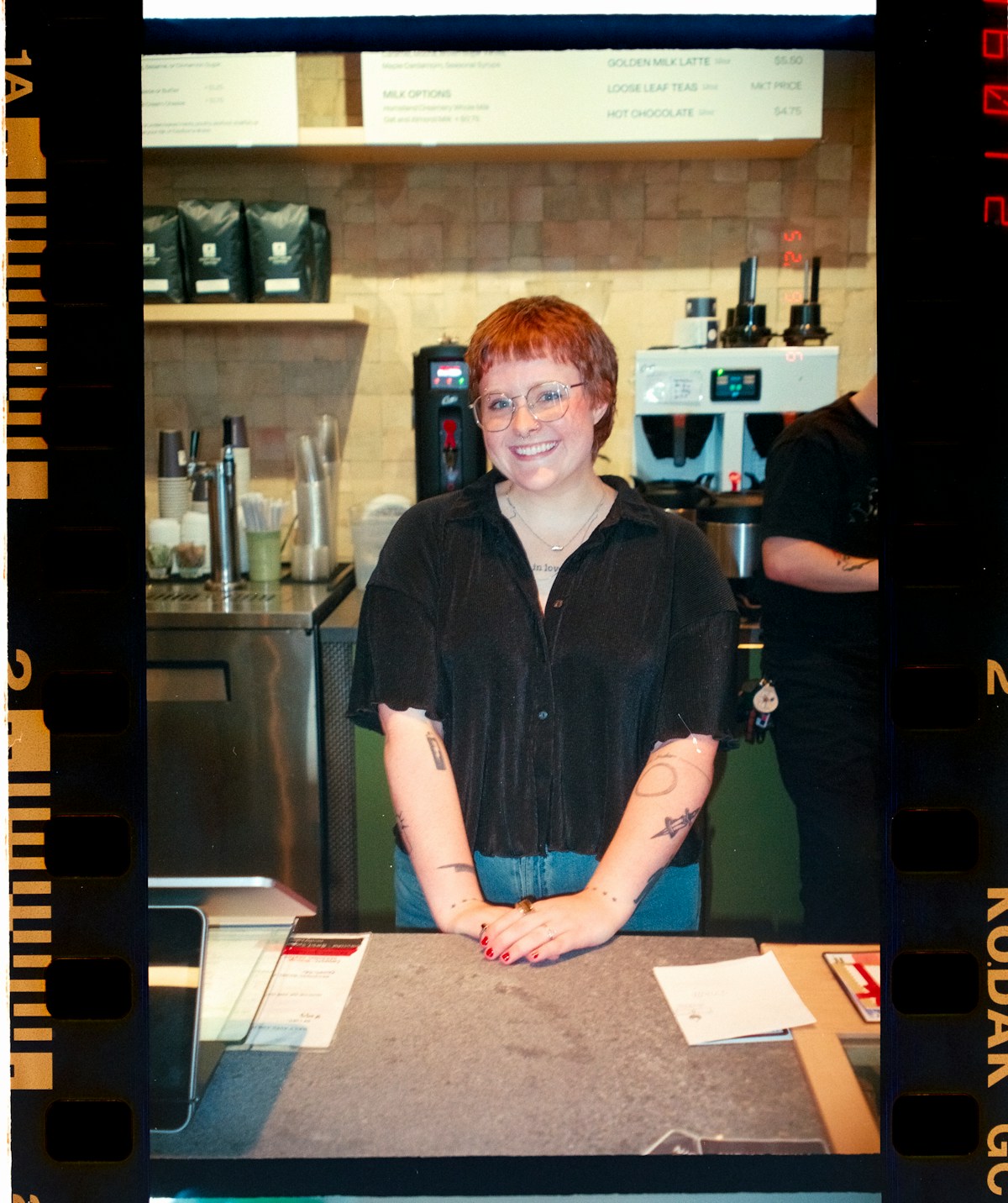 Barista standing behind the counter in a coffee shop.