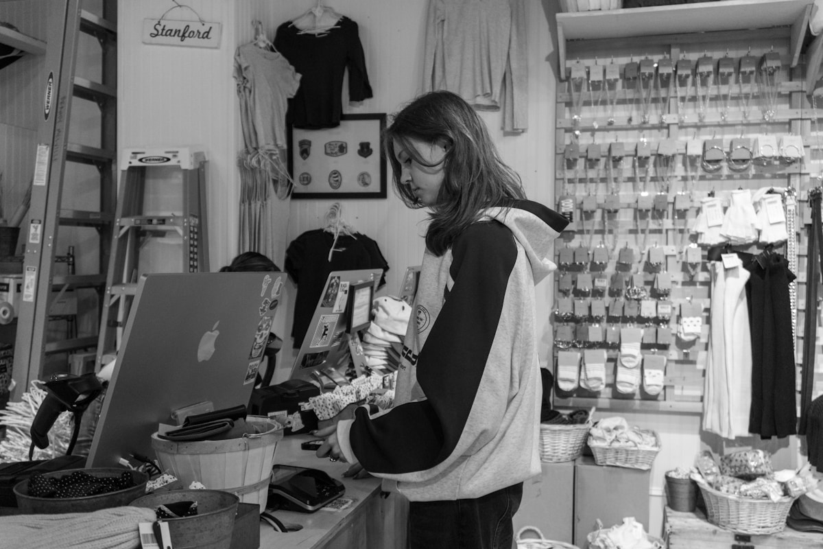 Retail employee working at a checkout counter in a store.